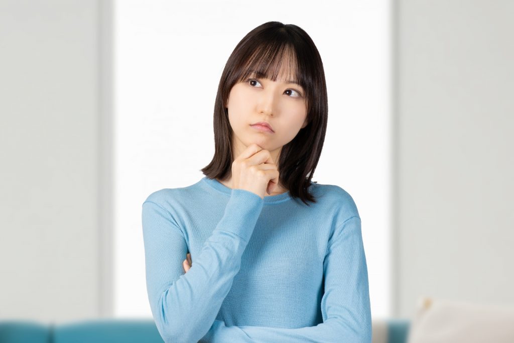 考えごとをする若い女性の様子