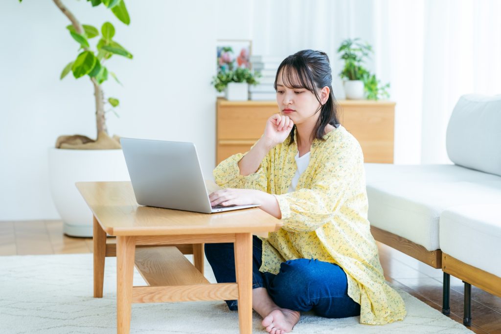 自宅でノートパソコンを操作する若い女性の様子